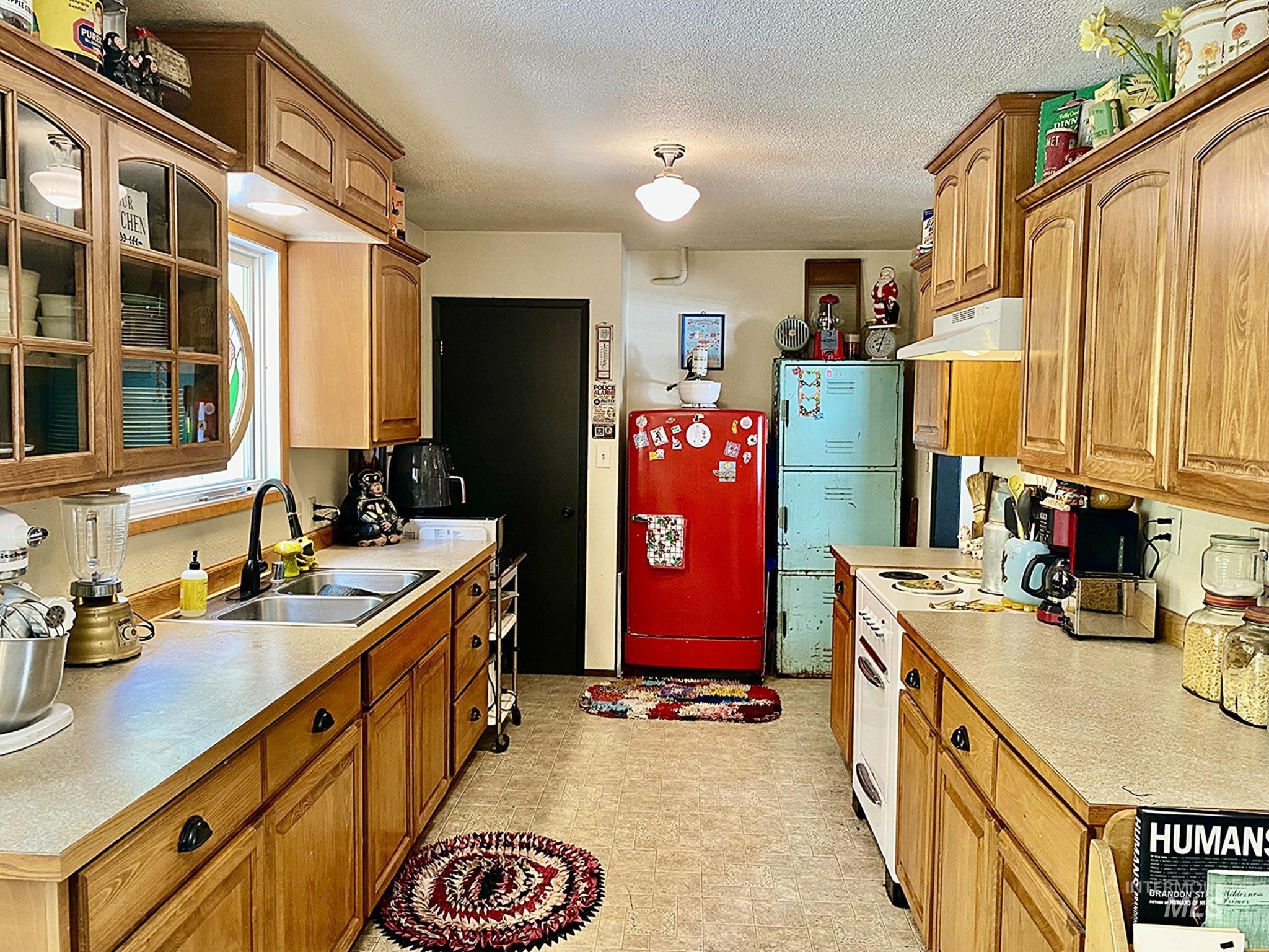 138 Timberline Drive Pierce, ID 83546 - Photo 8 of 28 Kitchen featuring refrigerator, light countertops, white electric range oven, a textured ceiling, and light flooring