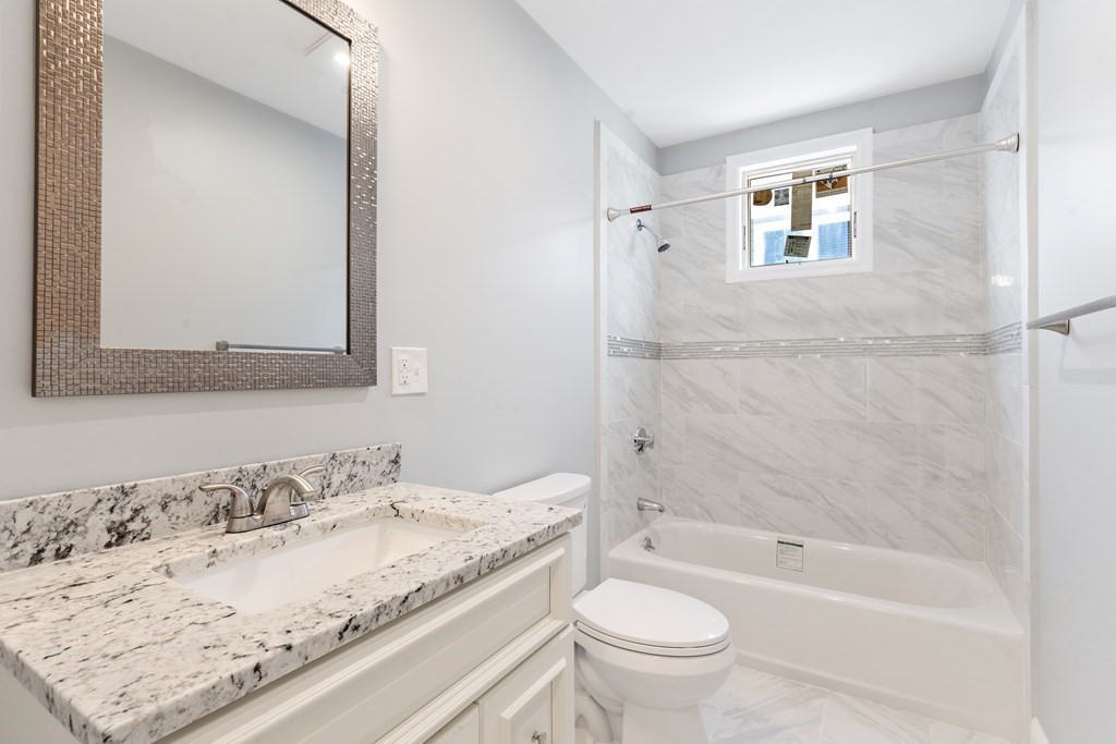 9 Wales Street, Unit 2 Boston, MA 02124 - Photo 7 of 15 a bathroom with a granite countertop sink a toilet and bathtub
