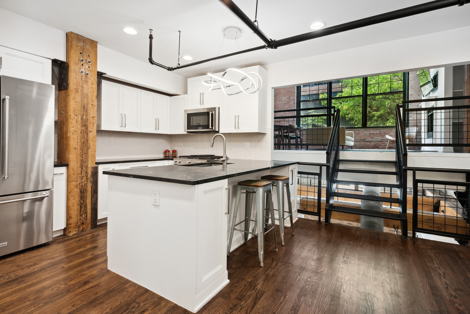 1000 West Washington Boulevard, Unit 148 Chicago, IL 60607 - Photo 10 of 18 a kitchen with kitchen island a counter top space a sink stainless steel appliances and wooden floor