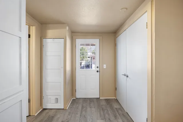 a kitchen with granite countertop cabinets stainless steel appliances and a wooden floor
