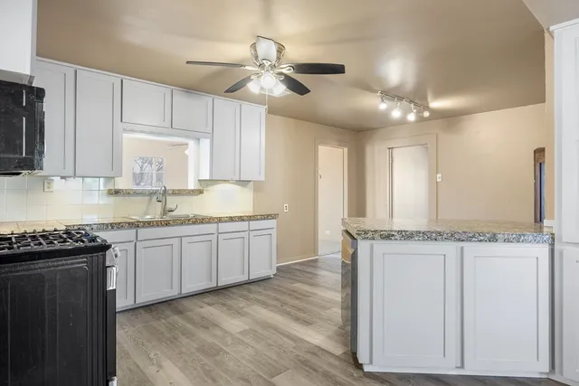 a kitchen with stainless steel appliances granite countertop a sink stove and cabinets