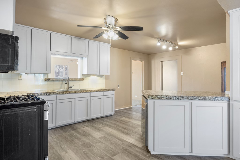 1200 North Street Kerrville, TX 78028 - Photo 13 of 50 a kitchen with granite countertop cabinets stainless steel appliances and a wooden floor