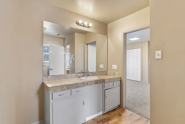 a en suite bathroom with a granite countertop sink a toilet and bathtub