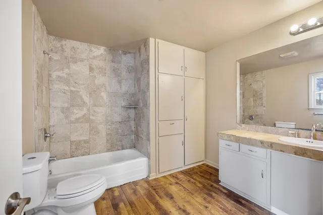 a view of an empty room with chandelier fan and fire place