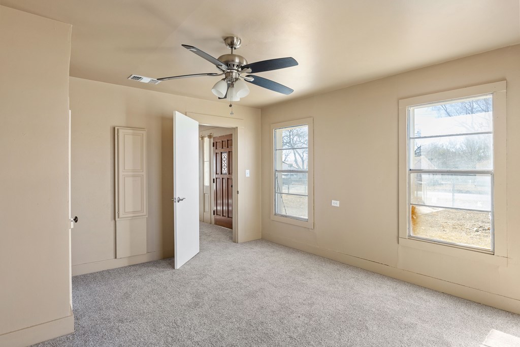 1200 North Street Kerrville, TX 78028 - Photo 20 of 50 a view of an empty room with chandelier fan and fire place