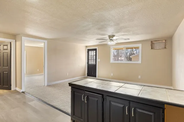 a kitchen with stainless steel appliances granite countertop a stove a sink and white cabinets