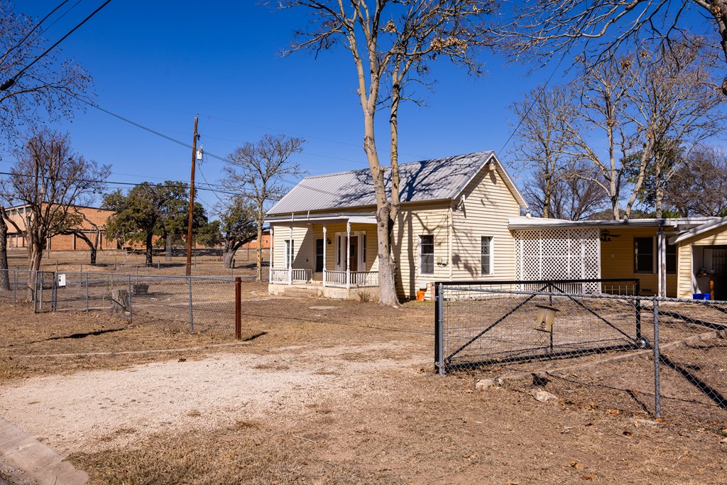 1200 North Street Kerrville, TX 78028 - Photo 6 of 50 a view of a white house with a yard covered with snow in the background