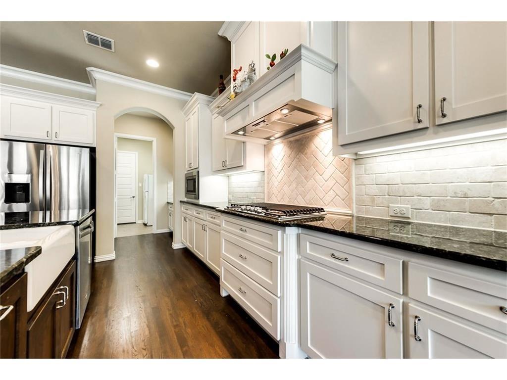 917 Pleasant View Drive Rockwall, TX 75087 - Photo 13 of 27 a kitchen with granite countertop a sink stainless steel appliances and cabinets