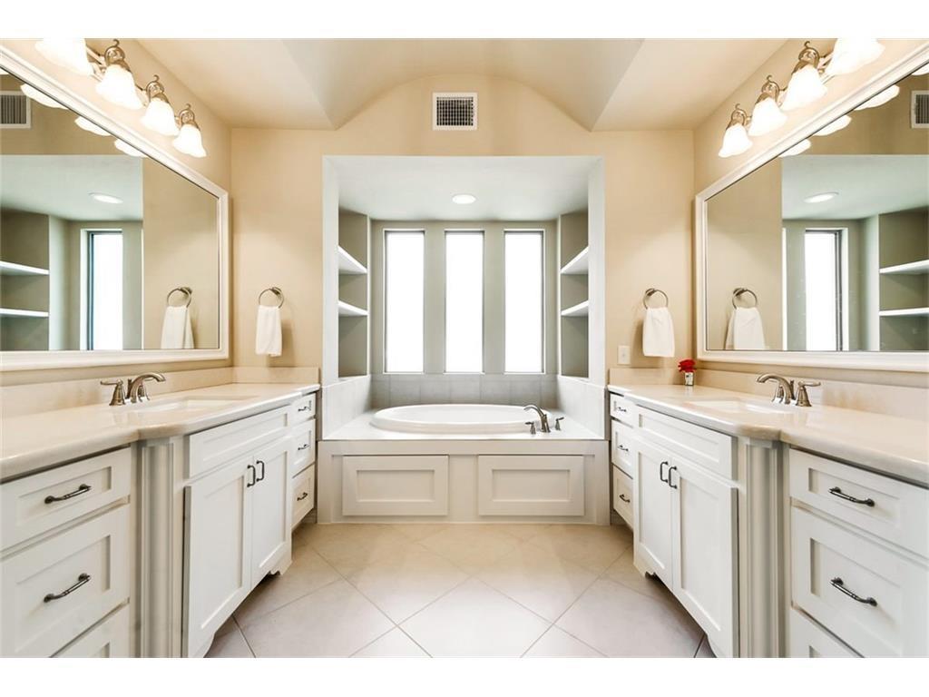 917 Pleasant View Drive Rockwall, TX 75087 - Photo 18 of 27 a large bathroom with a granite countertop double vanity sink a large mirror a bathtub and next to a window