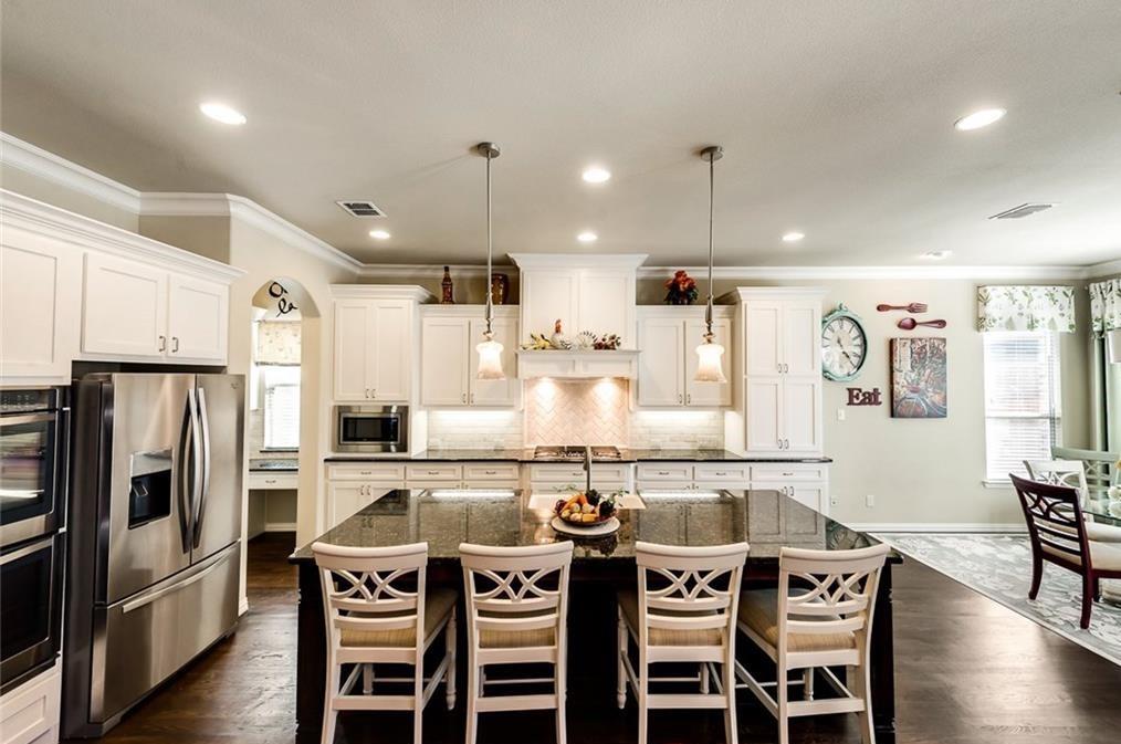 917 Pleasant View Drive Rockwall, TX 75087 - Photo 4 of 27 a kitchen with stainless steel appliances a dining table chairs refrigerator and microwave