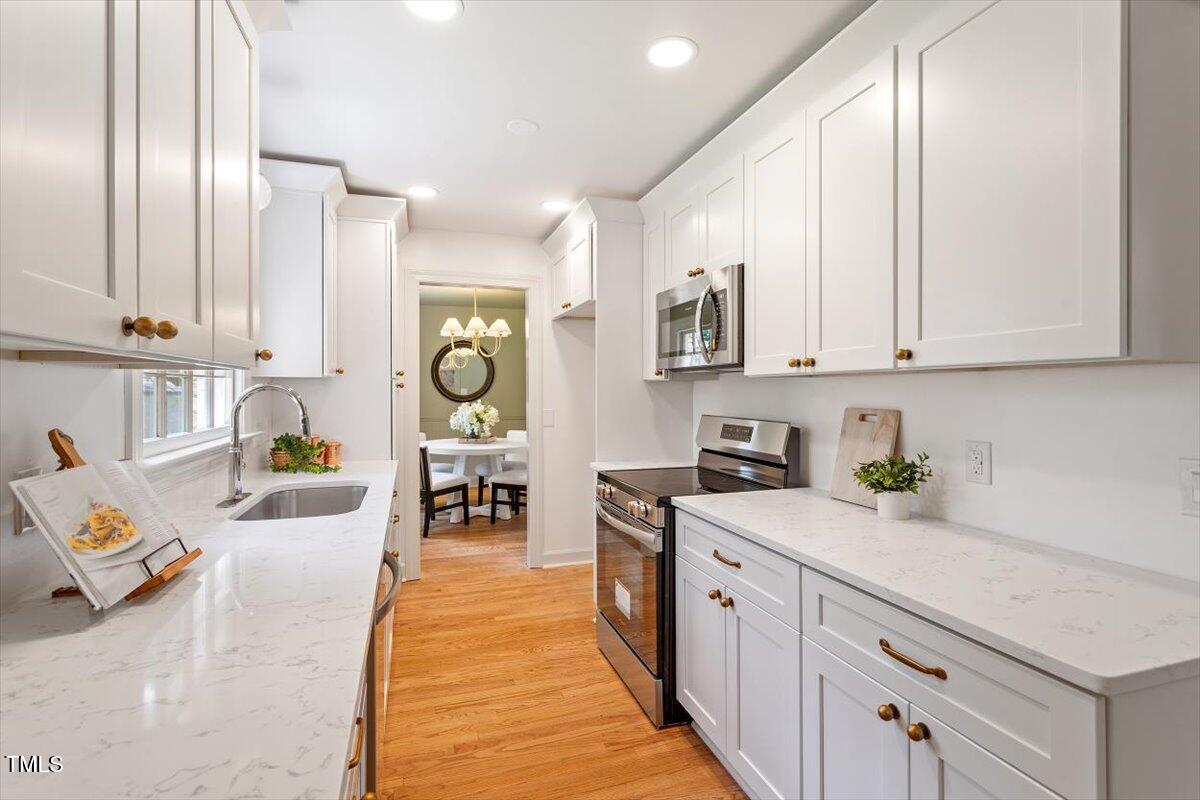6311 Brandywine Road Raleigh, NC 27607 - Photo 5 of 21 a large white kitchen with cabinets