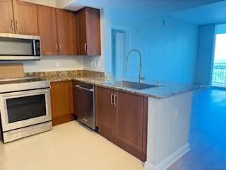 a kitchen with stainless steel appliances granite countertop a stove a sink and a microwave