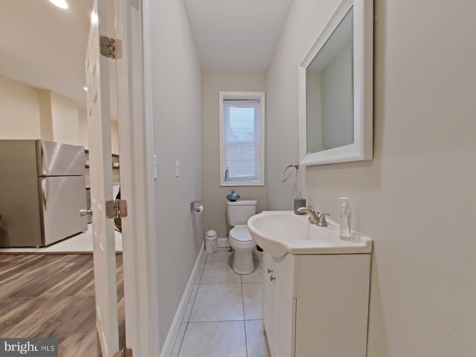 154 North 60th Street Philadelphia, PA 19139 - Photo 17 of 40 a bathroom with a sink a toilet and a mirror