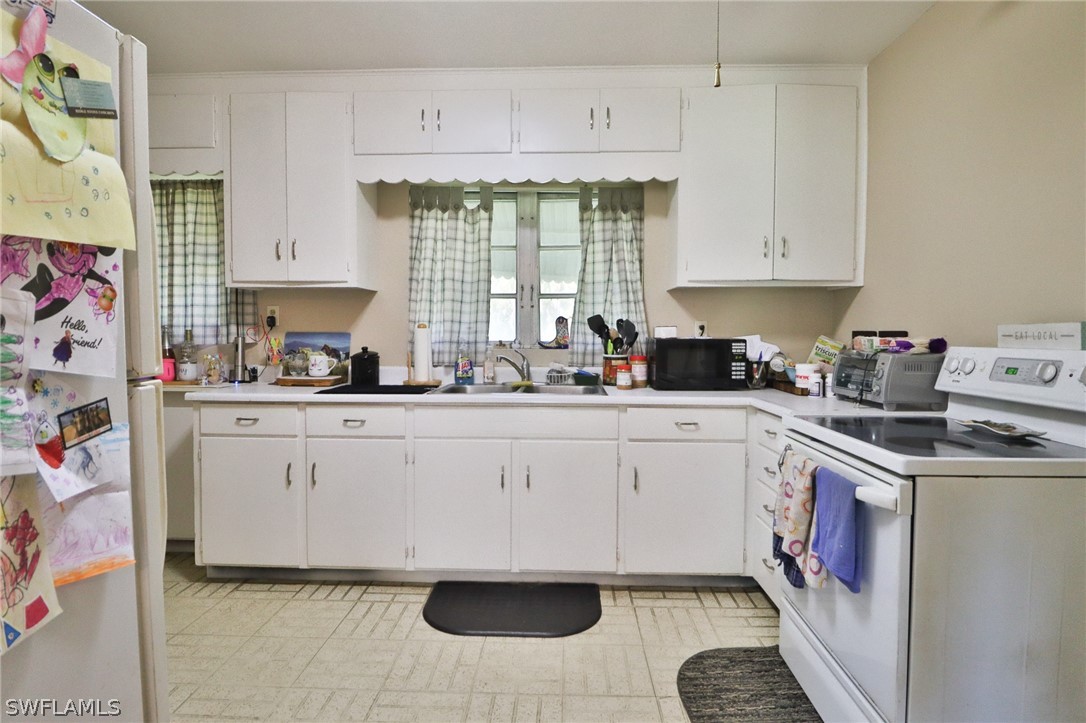 4260 Staley Road Fort Myers, FL 33905 - Photo 6 of 16 a kitchen with granite countertop white cabinets and white appliances