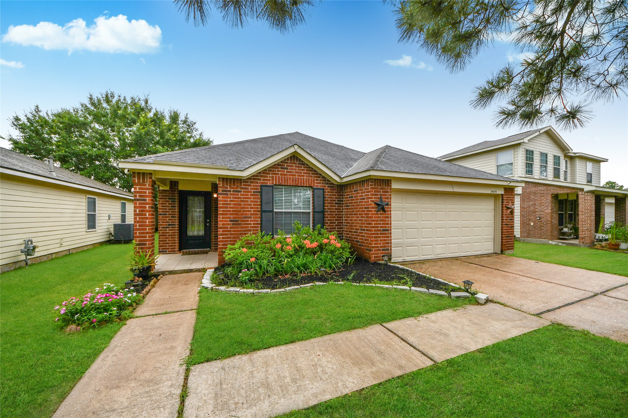 24019 Kingbriar Drive Spring, TX 77373 - Photo 6 of 41 A classic daytime front view that showcases the neat landscaping, prominent mature pine, and full garage facade, emphasizing the well-maintained condition and delightful curb appeal of the residence.