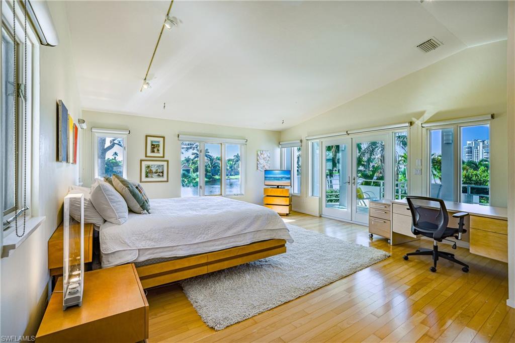 536 Turtle Hatch Road Naples, FL 34103 - Photo 19 of 28 Bedroom with french doors, access to outside, a desk, light wood finished floors, and lofted ceiling