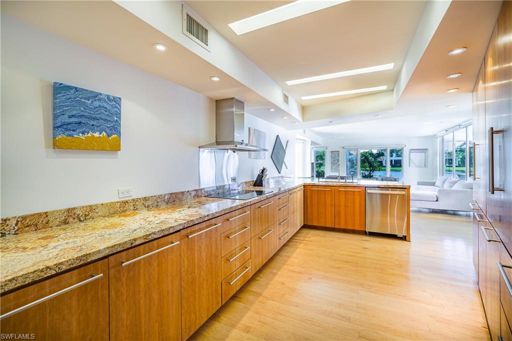 536 Turtle Hatch Road Naples, FL 34103 - Photo 28 of 28 Kitchen with modern cabinets, open floor plan, light stone counters, range hood, and light wood-style floors