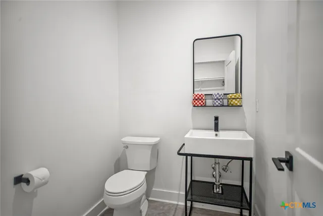 a bathroom with a toilet a sink and mirror