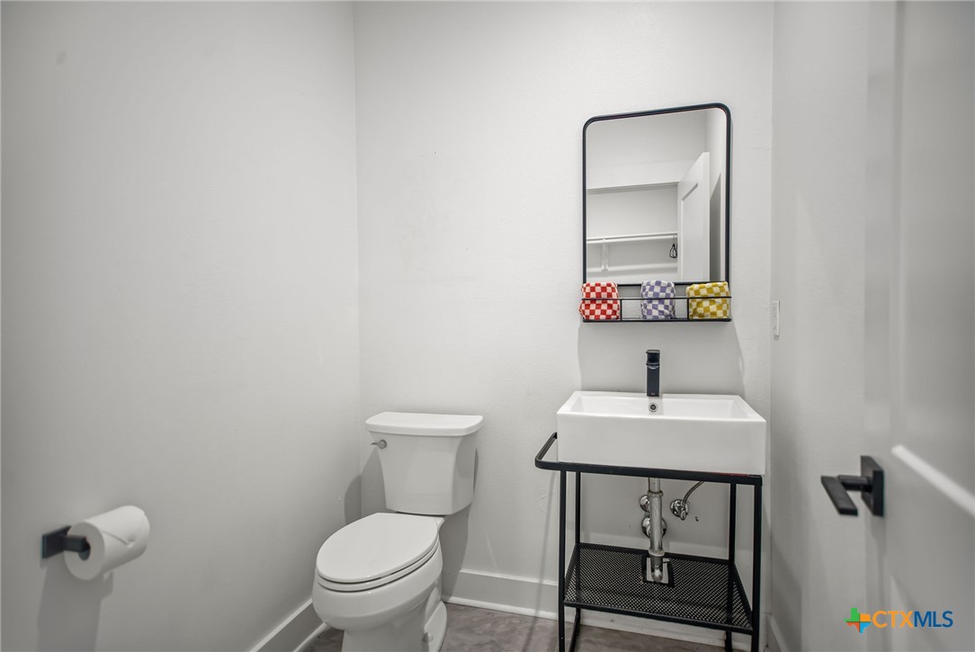 804 Tyler Avenue Port O'Connor, TX 77982 - Photo 20 of 43 a bathroom with a toilet a sink and mirror