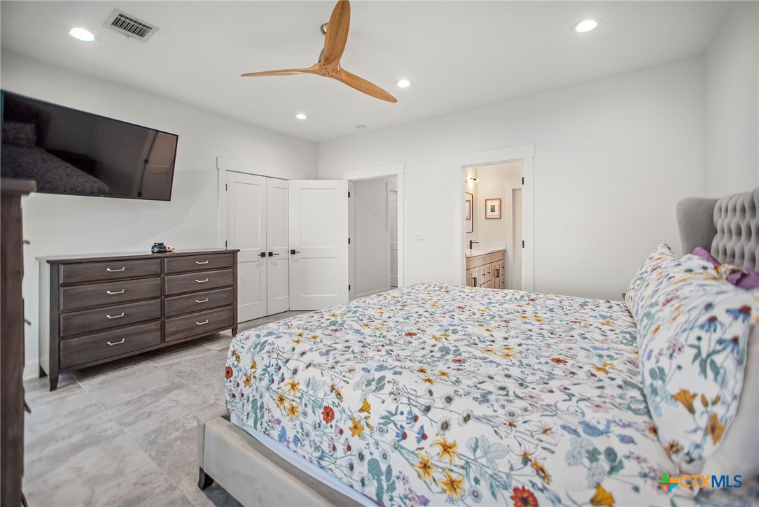 804 Tyler Avenue Port O'Connor, TX 77982 - Photo 25 of 43 a bedroom with a bed and flat screen tv