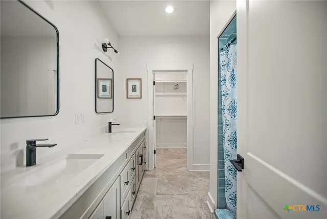 a bathroom with a double vanity sink a mirror and a bathtub