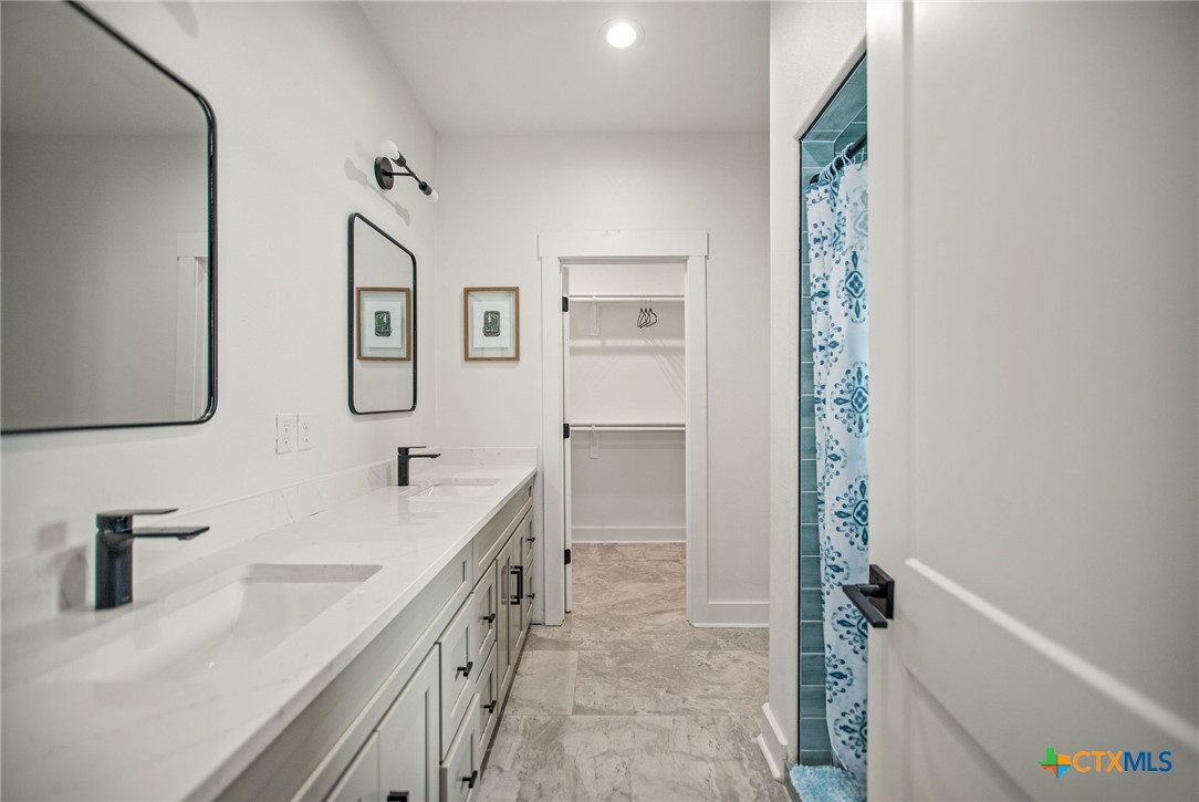 804 Tyler Avenue Port O'Connor, TX 77982 - Photo 26 of 43 a bathroom with a double vanity sink a mirror and a bathtub