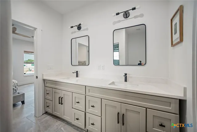 a bathroom with double vanity sink two mirror and a