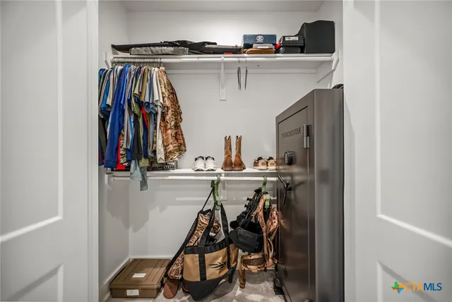a view of walk in closet with clothes and shoes