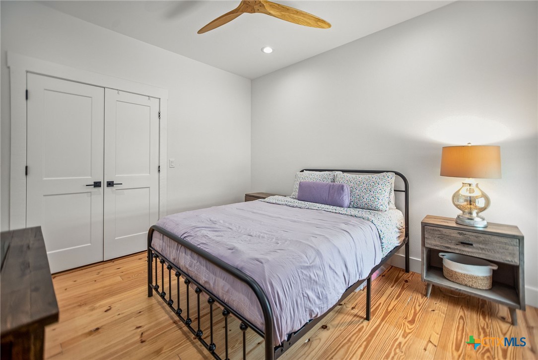 804 Tyler Avenue Port O'Connor, TX 77982 - Photo 37 of 43 a bedroom with a bed and wooden floor