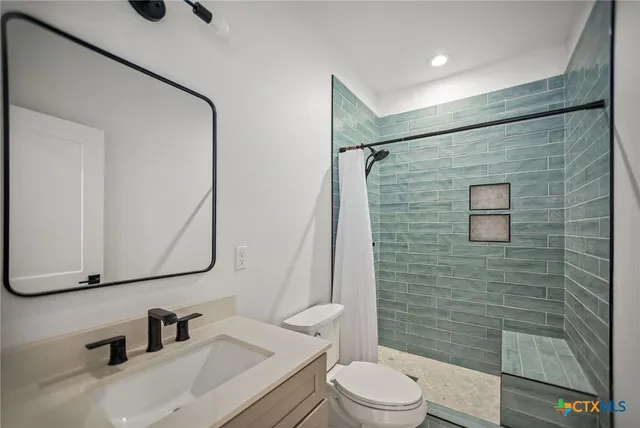 a bathroom with a sink a toilet and shower