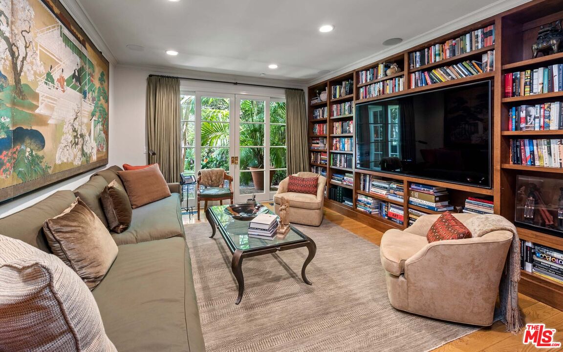 620 North Crescent Drive Beverly Hills, CA 90210 - Photo 4 of 23 a living room with furniture a flat screen tv and a book shelf