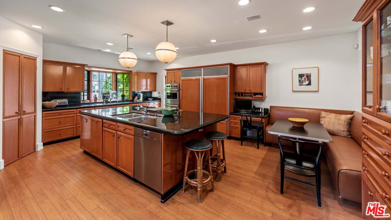 620 North Crescent Drive Beverly Hills, CA 90210 - Photo 6 of 23 a kitchen with stainless steel appliances granite countertop a stove refrigerator and cabinets