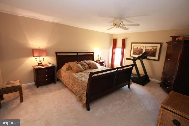14418 Autumn Crest Road Boyds, MD 20841 - Photo 22 of 26 a bedroom with a bed and a chandelier