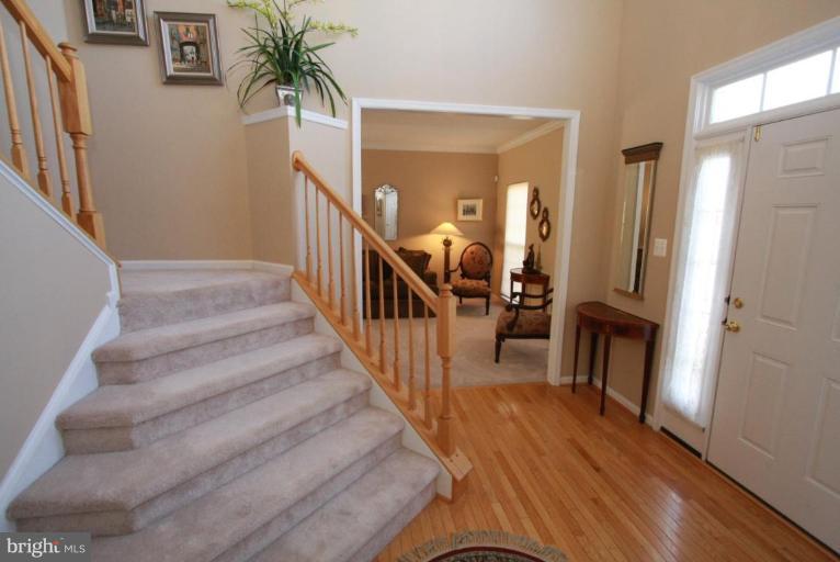 14418 Autumn Crest Road Boyds, MD 20841 - Photo 10 of 26 a view of a hallway with wooden floor and stairs