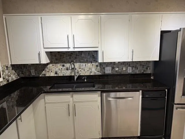 a kitchen with granite countertop a sink and cabinets