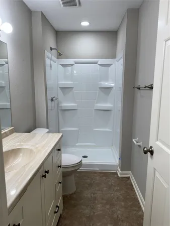 a bathroom with a sink a toilet a shower and a mirror