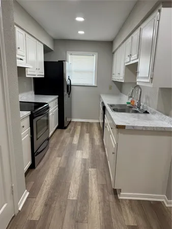 a kitchen with granite countertop a sink stove and refrigerator