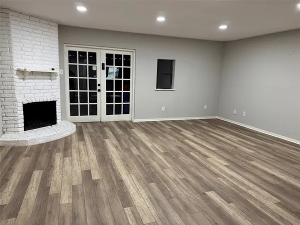 a view of an empty room with a fireplace and a window