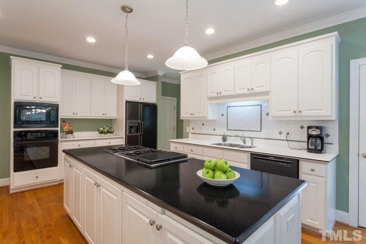 13921 Possum Track Road Raleigh, NC 27614 - Photo 13 of 25 Recessed Lighting, pendant Lighting, island cooktop, black appliances and tile backsplash adorn this great kitchen space!