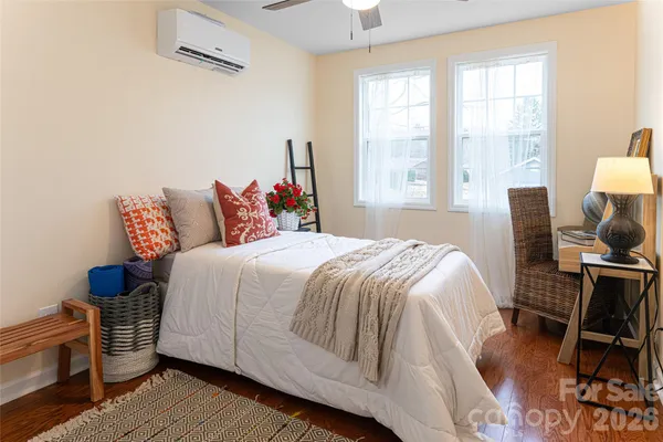 a bedroom with a bed a chair and a large window