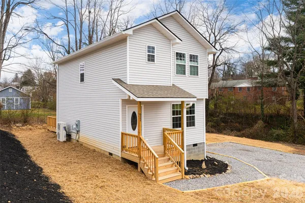 a view of a white house with a yard and furniture