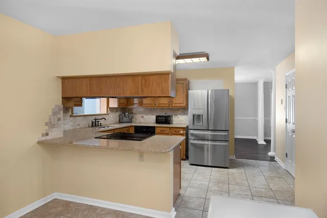 a kitchen with stainless steel appliances granite countertop a refrigerator a stove a sink and a microwave oven