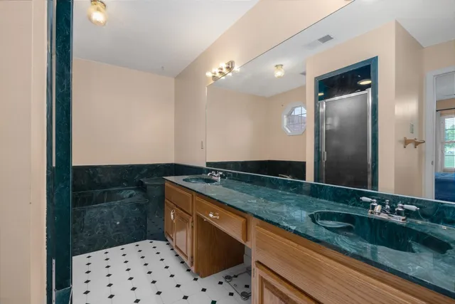 a bathroom with a granite countertop sink a large mirror and a shower
