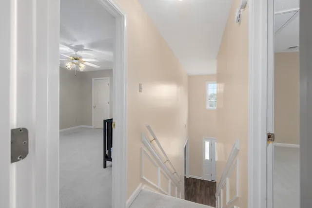 a view of a hallway with a chandelier fan