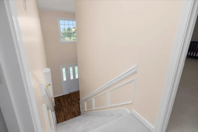 a view of staircase with white walls and a window
