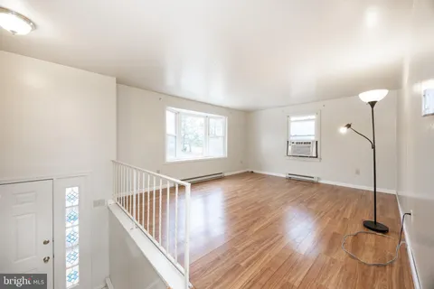 a dining room with furniture a chandelier and wooden floor