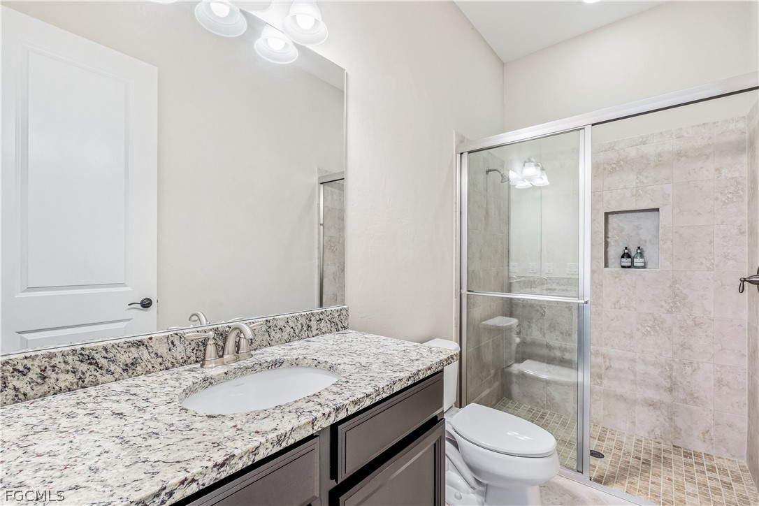 3341 Chestnut Grove Drive Alva, FL 33920 - Photo 22 of 44 a bathroom with a granite countertop sink a toilet and shower