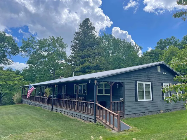 a living room with stainless steel appliances kitchen island granite countertop wooden floors and a view of living room