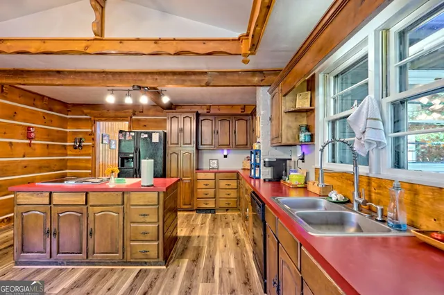 a living room with stainless steel appliances kitchen island granite countertop wooden floors and a view of living room