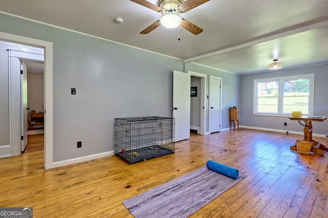 a view of a hallway with wooden floor and furniture